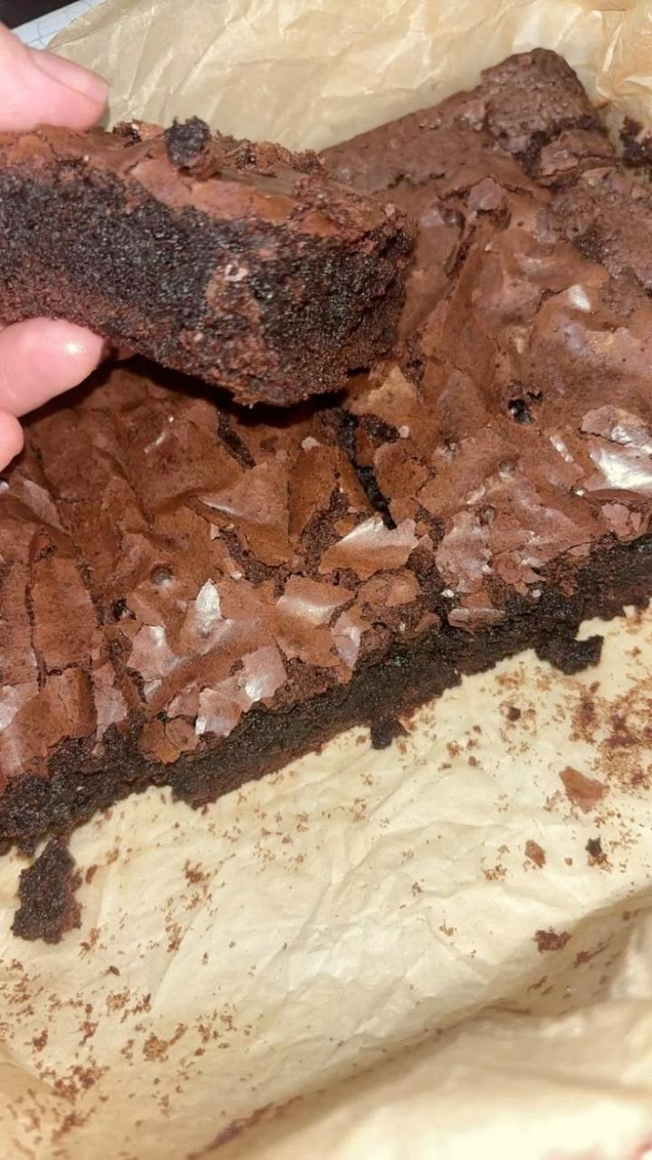 A brownie held up to show its rich chocolate centre